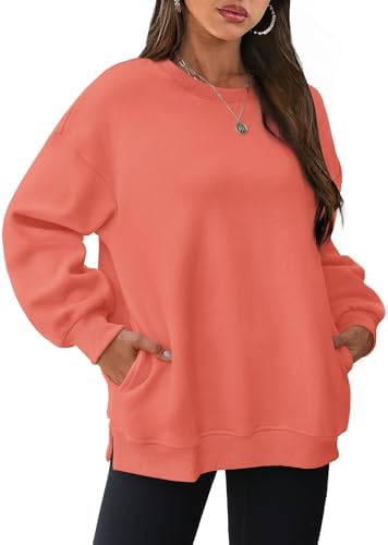 Bright coral orange warms up this fleece-lined crewneck, cut loose with deep side slits and hidden seam pockets.